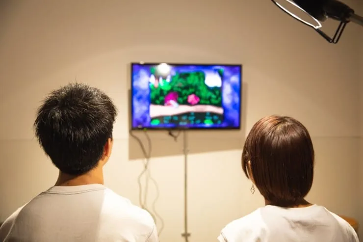 Two people watching a show together on a wall-mounted TV